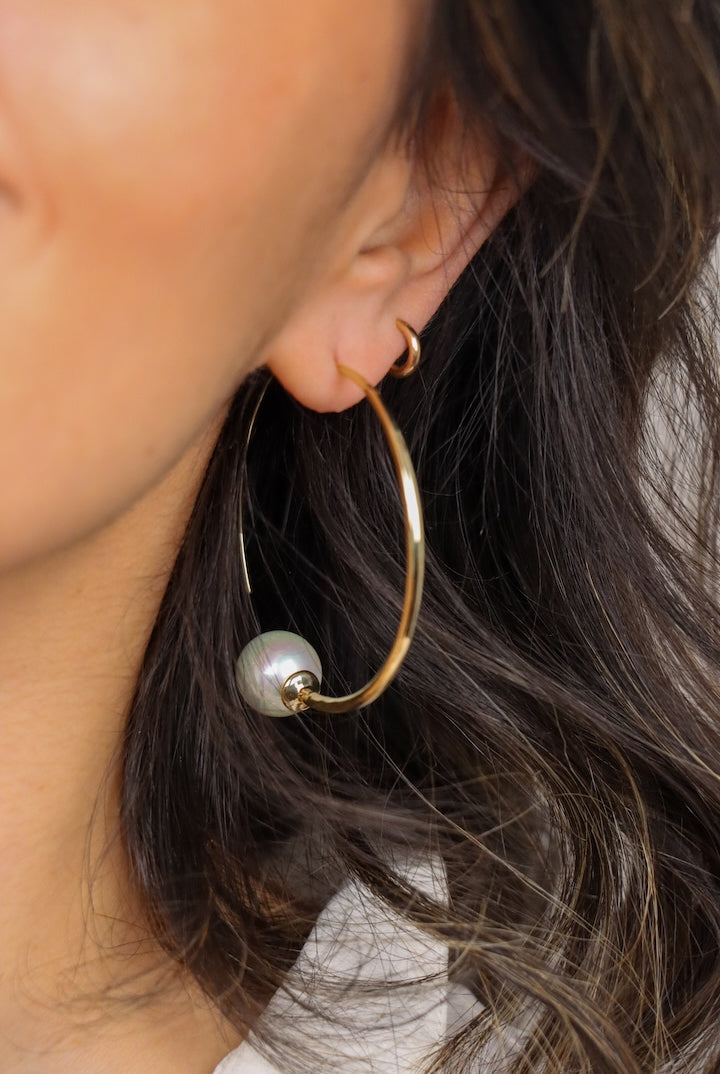 detail boucles d'oreilles Créoles fine dorée oreilles percées ornée d'une perles fantaisie