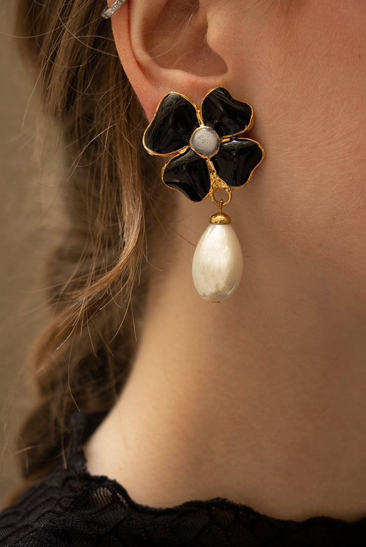Silhouette élégante arborant les boucles Amalfi noires, la goutte nacrée capte la lumière avec raffinement