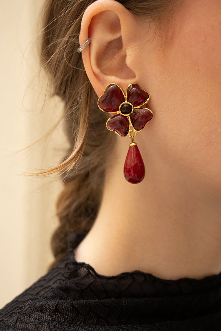 Femme arborant les boucles Amalfi améthyste, le mauve profond illumine le teint avec une sophistication singulière