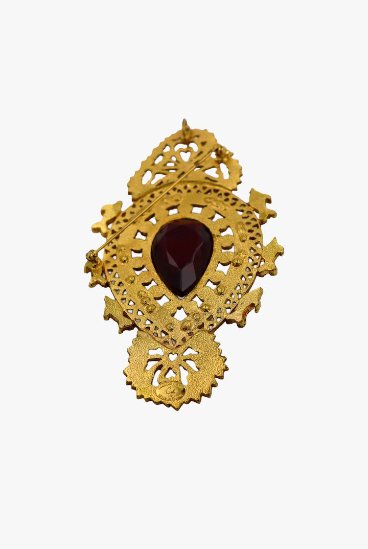 Grosse broche de créateur vintage dorée avec détail centrale d'une pierre rouge et ornée de petites perles blanches