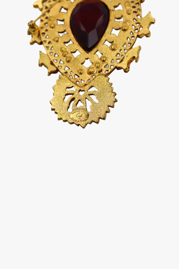 Grosse broche vintage avec détail centrale d'une pierre rouge signée au dos