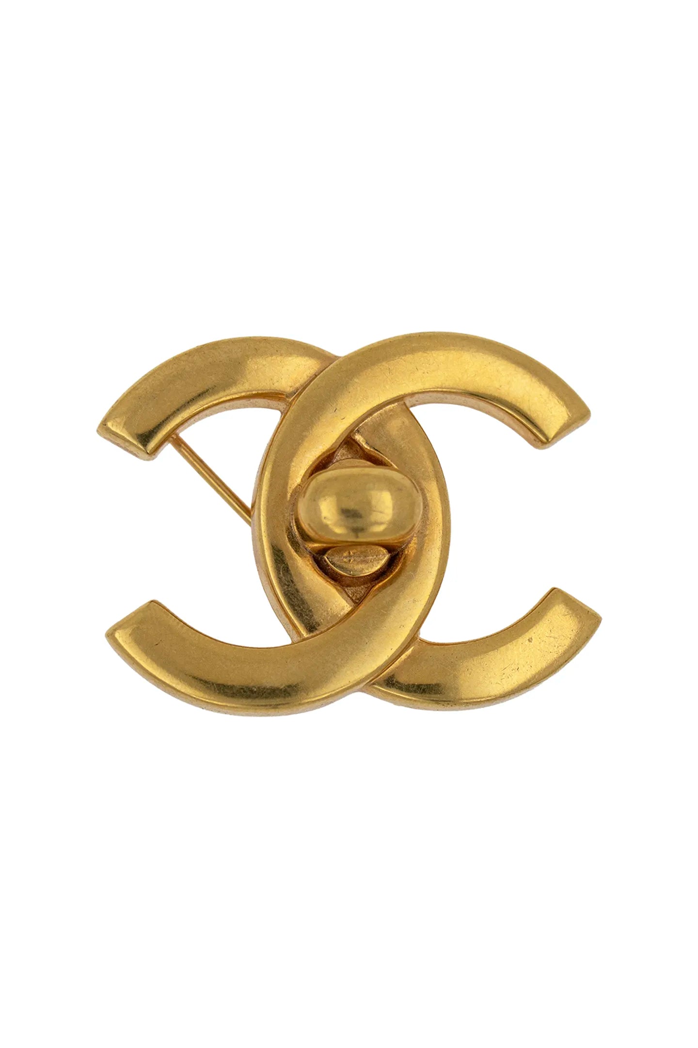 Broche CC vintage Chanel dorée à design lisse, fermoir central façon targette, pièce d'archive intemporelle.