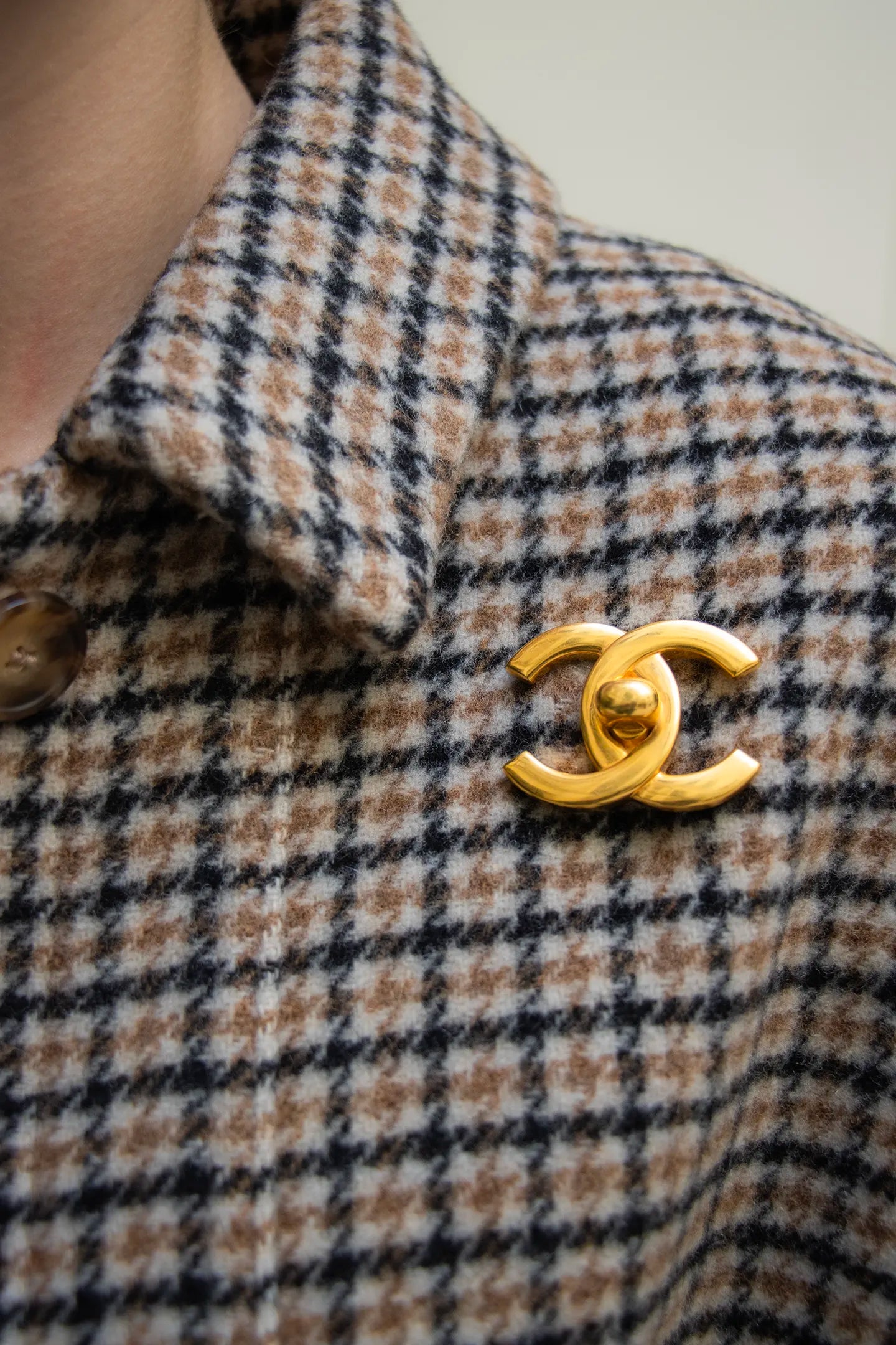 Broche portée CC vintage Chanel dorée à design lisse, fermoir central façon targette, pièce d'archive intemporelle.