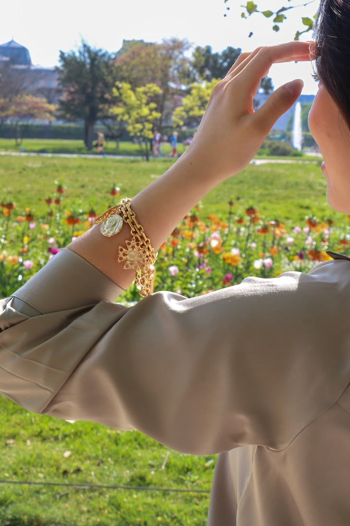 Bracelet avec breloques dorées soleil, pièces, lys