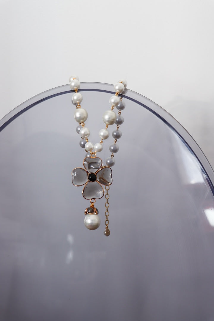 Collier en pâte de verre fumé gris et perles fantaisie pour femme sur un miroir