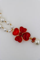 Collier en perles blanches fantaisie pendentif trèfles à quatre feuilles en pâte de verre rouge rubis femme détail doré