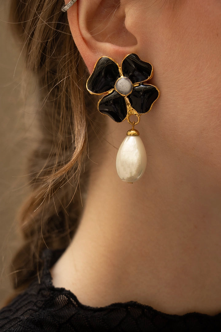 Silhouette élégante arborant les boucles Amalfi noires, la goutte nacrée capte la lumière avec raffinement