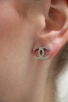 Boucles d'oreilles CC vintage Chanel  portées argentées, pavé de strass sur monture texturée, pièce d'archive.