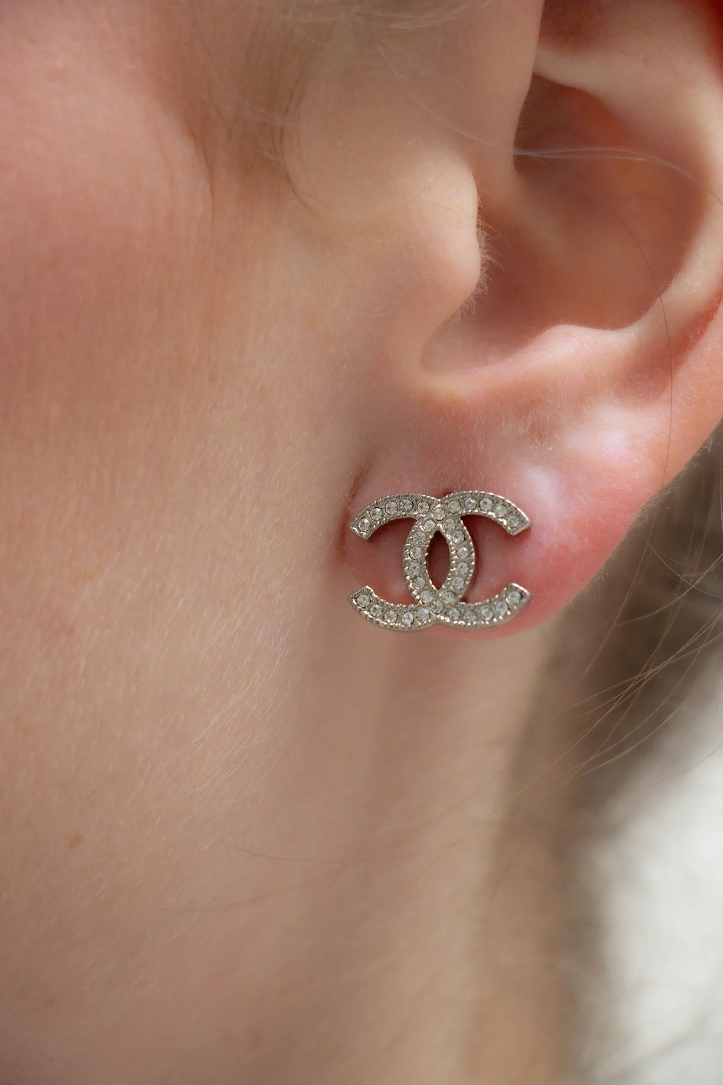 Boucles d'oreilles CC vintage Chanel  portées argentées, pavé de strass sur monture texturée, pièce d'archive.