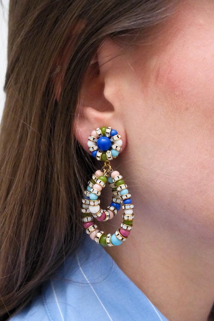 Boucles d'Oreilles en perles multicolore bleu, vert, rose et turquoise petite small et pendantes avec un fermoir clip portées à l'oreilles d'une femme 
