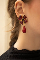 Femme arborant les boucles Amalfi améthyste, le mauve profond illumine le teint avec une sophistication singulière