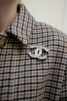 broche portée détail Éclat des cristaux baguette taillés sur le double C argenté, design exclusif et raffinement intemporel.