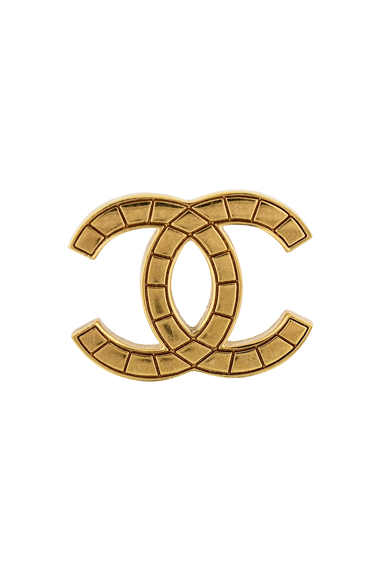 Broche CC vintage Chanel dorée, motif matelassé segmenté sur monture métal, pièce d'archive intemporelle.