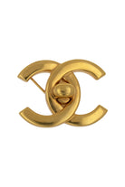 Broche CC vintage Chanel dorée à design lisse, fermoir central façon targette, pièce d'archive intemporelle.