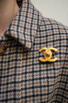 Broche  portée CC vintage Chanel dorée à design lisse, fermoir central façon targette, pièce d'archive intemporelle.