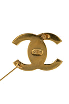Dos doré de la broche CC, poinçon Chanel 96 P Made in France gravé et épingle déployée, artisanat signé.