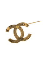 Dos texturé doré de la broche CC, poinçon Chanel gravé et épingle déployée, artisanat vintage authentique.