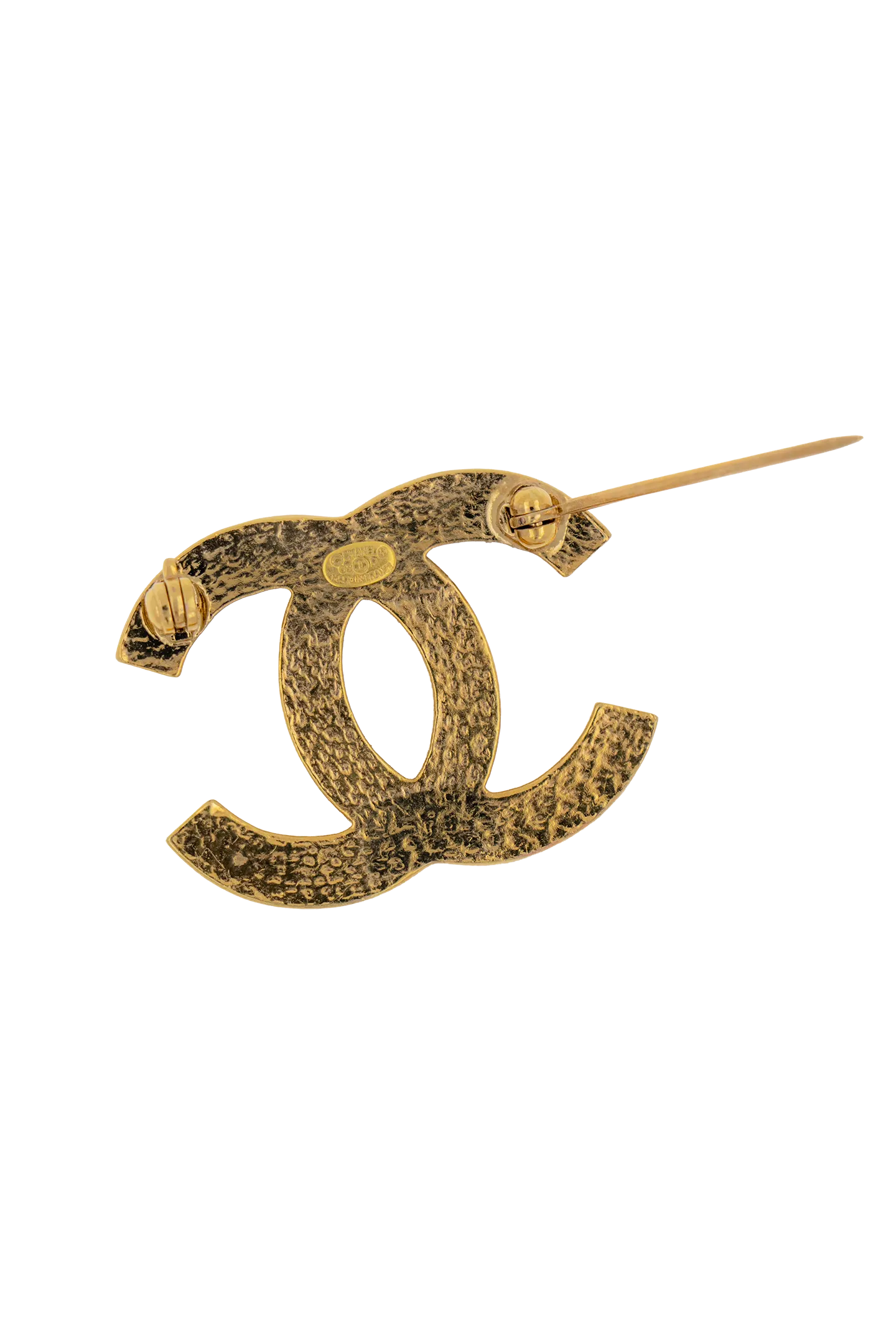 Dos texturé doré de la broche CC, poinçon Chanel gravé et épingle déployée, artisanat vintage authentique.
