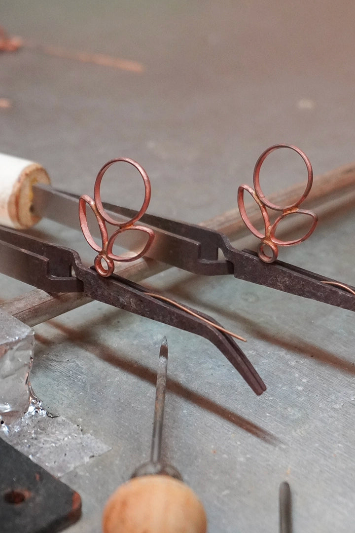 Paire de boucles Emma en cours de création, verre soufflé à la flamme révélant l'éclat et la profondeur de la matière