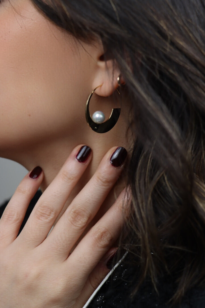 Créole dorée ornée d'une perle blanche 